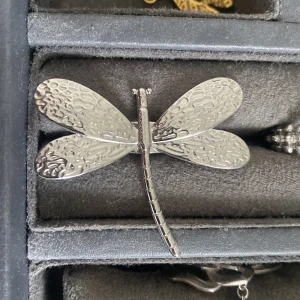 Stor silverfärgad ring med trollslända - Unik ring i silverfärgad metall formad som en trollslända med detaljerade, texturerade vingar. Statement piece som verkligen sticker ut och ger coola naturvibbar till din stil. Köp på en marknad utomlands.