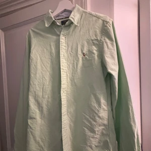 Ljusgrön Oxford-skjorta Polo Ralph Lauren - Snygg ljusgrön Oxford-skjorta från Polo Ralph Lauren i slim fit-modell. Skjortan har klassisk krage, knappar framtill och den ikoniska broderade loggan på bröstet. Tillverkad i bomull och har långa ärmar. Perfekt för en clean och fräsch stil. 1699kr ny!
