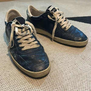 Philippe Model blåa sneakers - Snygga blåa sneakers från Philippe Model med vita detaljer och vit snörning. Klassisk låg modell med rund tå och platt sula. Handgjorda i Italien och har en cool vintage vibe med kontrasterande vit häl och sula. Storlek 41!