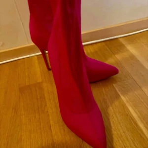 Rosa stövletter med spetsig tå - Säljer ett par riktigt snygga rosa stövletter med hög klack och spetsig tå. Skorna har en tight passform och är perfekta för att sticka ut. Materialet känns som syntet och färgen är intensivt rosa. Perfekta för dig som vill ha statement boots.