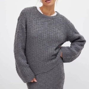 Grå stickad tröja från NA-KD - Grå kabelstickad tröja från NA-KD. Aldrig använd eller tvättad, lappen sitter kvar. Nästan slutsåld på hemsidan! Kliar ej!