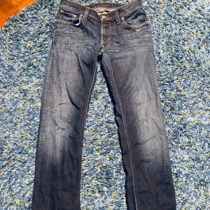 Mörkblå jeans från Nudie Jeans - Snygga mörkblå jeans från Nudie. Byxorna har ett fåtal små hål men är knappast synliga.