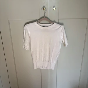 Vit kortärmad tröja från Zara❤️ - En stilren vit tröja från Zara med korta ärmar och rund halsringning. Tröjan har en ribbad nederkant som ger en snygg passform. Perfekt att matcha med jeans eller kjol för en clean look.🫶🏼