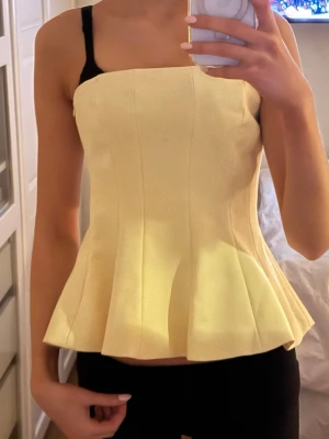 Ljusgul topp med volang - Assnygg tube topp från zara köpt i somras men som har prislappen kvar!! Säljer eftersom att den inte kommit till användning så mycket. Fungerar både som festtopp och till sommaren! Storlek XS men passar även S!