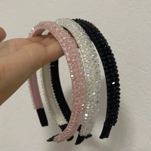 Glittriga hårdiadem i rosa, vit och svart - Tre snygga hårdiadem med glittriga pärlor i färgerna ljusrosa, vit och svart. Diademen har en rundad form och är täckta med små fasetterade pärlor som ger ett riktigt coolt och glittrigt intryck. Perfekt för att lyfta din look med lite extra bling.