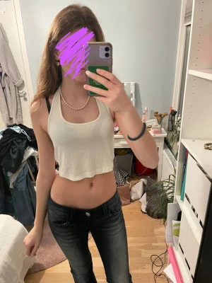 Vit croppad linnetopp - Säljer en enkel och fräsch vit croppad linnetopp med breda axelband och rundad halsringning. Toppen är ärmlös och har en avslappnad passform som passar perfekt till jeans eller kjol. Perfekt för varma dagar eller lager på lager.