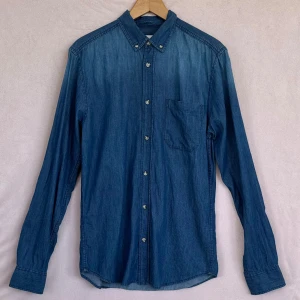 ”Ombre” blå slim-fit jeansskjorta i S. Cubus - *Cubus Jeansskjorta, Slim fit i S. Endast tvättad men oanvänd.    																																																																																				  *Har en viss ( ombre-effekt), dvs. överdelen av skjortan är lite ljusare än resten 																																			     																	   *Ca-mått i cm: axel: 42, bröst: 46, längd: 75. 