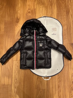 Moncler Maya Giubbotto + Dustbag - Hej! Säljer nu min fina Moncler Maya + en dustbag som kan användas till väska och förvaring när jackan inte används. Den är i bra skick endast använd vid fåtalet tillfällen och sparsamt använd. Säljes endast pågrund av att jag inte passar i den längre.  Storlek Medium. Passar folk som vanligtvis bär Small & Medium.  Fint skick. Varm och funkar riktigt bra på vintern.  Jackan har en scanningsbar QR-kod som bevisar att den är autentisk. Loggan kan oxå scannas med nfc. Sparsamt använd, fintskick!