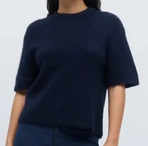 Mörkblå stickad tröja med kort ärm - Snygg mörkblå stickad tröja med rund hals och korta ärmar.