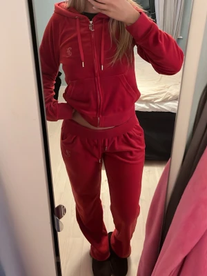 Juicy Couture set - Jag säljer ett rött Juicy Couture set med text bak på både tröjan och byxorna. 