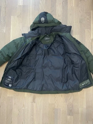 Sail Racing dunjacka – grön/svart – mycket bra skick – 1999 kr - Sail Racing dunjacka i mycket bra skick. Varm, stilren och funktionell jacka som passar perfekt för höst och vinter ❄️  Jackan har: • Dunfyllning (Allied Feather & Down, 500 fill power) • Justerbar huva • Dragkedjefickor • Vind- och vattenavvisande material • Snygg grön färg med svarta detaljer • Diskret Sail Racing-logga på bröstet och huvan 	•	Märke: Sail Racing 	•	Typ: Dunjacka / vinterjacka 	•	Skick: Mycket bra skick, sparsamt använd 	•	Passform: Regular 💰 Pris: 1999 kr 📦 Skickas snabbt!