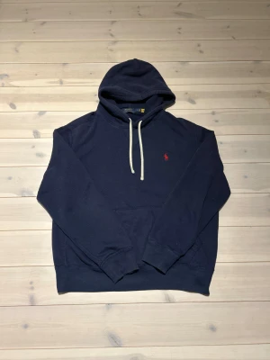 Ralph Lauren - Snygg mörkblå hoodie från Polo Ralph Lauren med klassisk röd logobrodyr på bröstet. Använd fast i bra skick | inga fläckar eller hål | lite nopprig men inget som syns på håll | nypris 2000+ | perfekt som julklapp | pris går att diskutera vid snabb och enkel affär✅