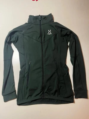 Mörk grön Haglöfs jacka XS dam - Säljer en svart funktionsjacka från Haglöfs i dammodell, storlek XS. Perfekt för utomhusaktiviteter och träning