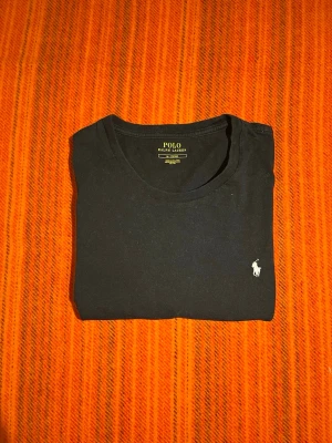 T-shirt från ralph lauren - Svart t-shirt med vit brodering från Polo Ralph Lauren. Säljer för att den inte passade men tröjan är i bra skick. St:Medium. Skriv om du har någon fundering
