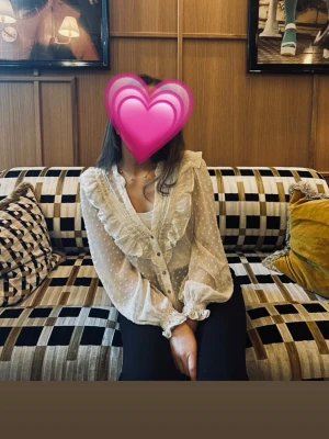 Vit volang blus  - Säljer denna vit/beiga volangblus från Zara i jättebra skick! Blusen är endast använd fåtal gånger och är i storlek xs. Obs! Bild 2 är lånad!