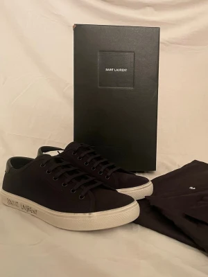 Saint Laurent skor  - Säljer ett par helt nya Saint Laurent skor med allt og med, aldrig använda! Skomodellen heter Malibu. Färg: Svart. Storlek: 41. Vårt pris är endast 3799 kr och nypris ligger på runt 7200 kr. Priset är ej hugget i sten. Hör av er vid frågor eller funderingar! 