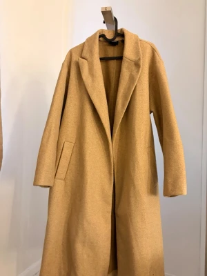 Beige kappa med bälte  - Beige kappa från Vero Moda med bälte i midjan. 
