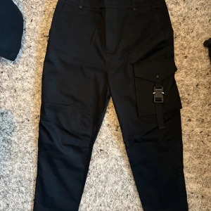 Svarta Dior cargobyxor  - Dior Cargo-byxor – Svart 👖 Storlek: XS 🖤 Färg: Svart ✨ Skick: 10/10 – i nyskick, sparsamt använda eller aldrig använda 💼 Modell: Cargo – med flera fickor