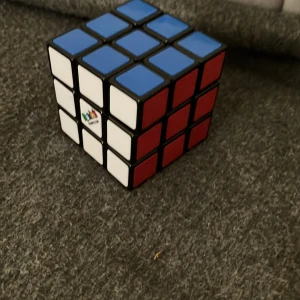 Rubik's Cube 3x3 - Klassisk Rubik's Cube 3x3 i mycket gott skick. Alla färger är tydliga och klara, och kuben roterar smidigt. Perfekt för både nybörjare och erfarna problemlösare. Inga synliga defekter eller slitage. Originalprodukt med Rubik's-logga.