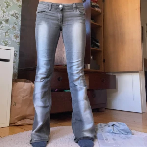 Grå bootcut jeans med slitningar - Säljer dessa populära jeans från weekday och cheap Monday, bra skick! Har klippt bort den gröna lappen på baksidan vilket syns på bild två. 