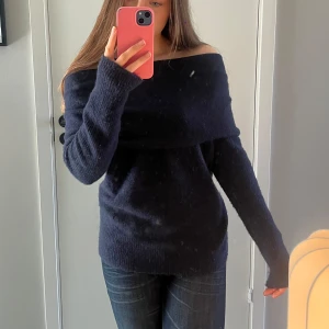 Mörkblå offshoulder stickad tröja Zara - Mysig mörkblå stickad tröja från Zara med offshoulder-design och långa ärmar. Tröjan har en bred, nedvikt krage som ger en snygg och avslappnad look. Perfekt för kyliga dagar och enkel att styla med jeans eller kjol.
