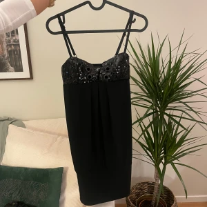 Svart paljettklänning med smala axelband - Svart kortklänning från med smala axelband och glittrig paljettbyst. Klänningen har en rak passform. Klänningen är helt ny och inte använt🩷