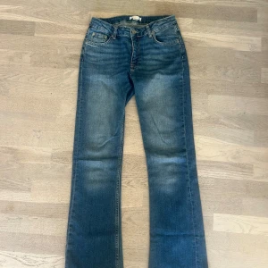 Blå bootcut jeans från Gina Tricot - Snygga blå jeans från Gina Tricot i klassisk bootcut-modell i stl 158. Jeansen har fem fickor, normalhög midja och är tillverkade i mjukt denimtyg.