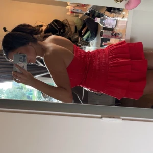 Röd kortklänning med volang - Röd kortklänning med volang, nyligen köpt på Gina tricot. Prislappen är borttagen men klänningen har aldrig använts. Strl M men passar både en xs och s då den är väldigt stretchig.