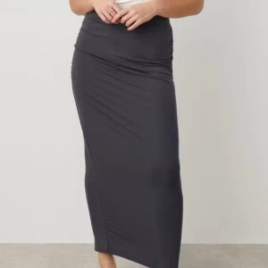  långkjol med rynkade detaljer - Säljer en mörk mörk grå långkjol med rynkade detaljer på sidorna. Kjolen har en tight passform och är gjord i ett mjukt och stretchigt material.  (Ordinarie pris 299kr)