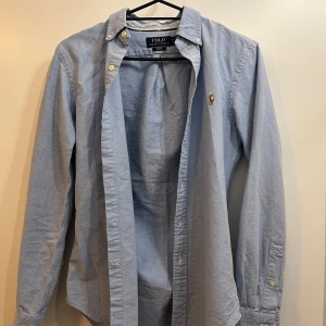 Ralph Lauren skjorta  - Säljer en snygg ljusblå Ralph Lauren skjorta som är i väldigt bra skick och använd sparsamt. Storlek XS i Slim fit modell. Hör av er för flera bilder eller frågor!