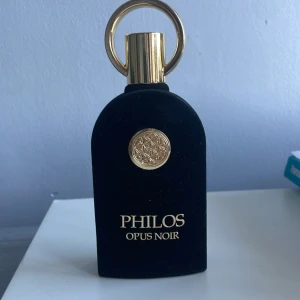 Philos Opus Noir Parfym - Snygg och stilren parfymflaska med gulddetaljer från Philos. Perfekt för dig som vill sticka ut med en exklusiv look. Namnet Opus Noir ger en mystisk och modern.