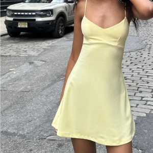 Ljusgul kort klänning med smala axelband - Supersöt ljusgul kort klänning med smala axelband. Materialet känns mjukt och lätt. Aldrig använd och lappen sitter kvar!!💛🙌🏼