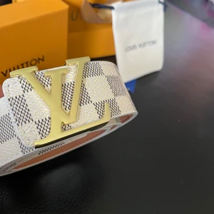 Louis viutton bälte - Säljer en helt ny Louis Viutton bälte. Den ingår box,påse,band och hålgörare. Färgen är vit  och storlek är 120cm. Den är tillverkad i Frankrike.