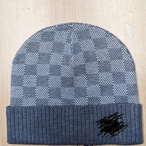 Grå rutig mössa med ribbad kant - Snygg grå mössa med rutigt mönster och bred ribbad uppvikning. 