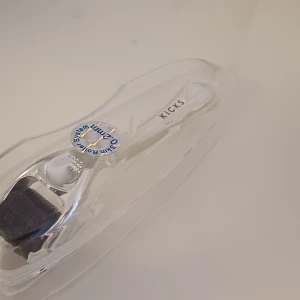 Skin Roller från Kicks - Skin Roller från Kicks med 0,5 mm nålar, perfekt för att boosta hudvårdsrutinen. Handtaget är vitt och verktyget kommer i ett genomskinligt plastfodral. Passar dig som vill ha extra glow och jämnare hudstruktur. Helt ny