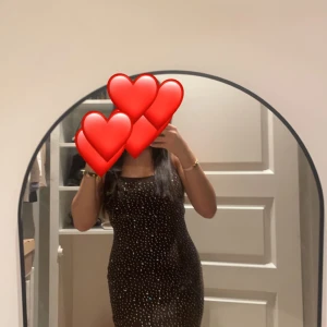 Svart glittrig kort klänning - Supersnygg brun lång klänning med glittriga detaljer. Tight passform och ärmlös design som framhäver figuren. Perfekt för dig som vill sticka ut och glänsa. Passar till alla som älskar att synas och vill ha en trendig look.