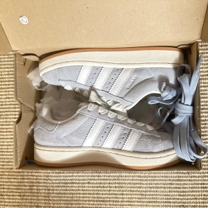 Adidas Campus 00 - Snygga Adidas Campus sneakers i ljusgrå/ljusblå. Strl 36, använd endast en gång så de är i väldigt fint skick!