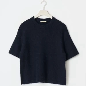 Mörkblå stickad tröja från Gina ticot  - En stilren mörkblå stickad tröja från Gina tricot med kort ärm och rund halsringning. Tröjan har en boxig passform och är gjord i ett mjukt, fluffigt material som känns lyxigt och bekvämt. Perfekt för lager-på-lager och snygg till både jeans och kjol.