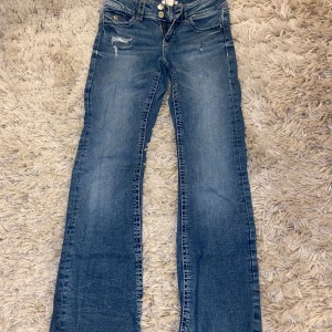Blå bootcut jeans med slitningar - Snygga blå jeans med bootcut och slitna detaljer framtill. Från Gina Tricot i storlek 158