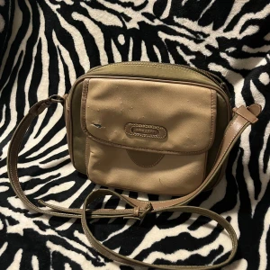 Beige axelväska med randigt foder🖤 - Lite trasig där fram men annars i bra skick.🖤🍒