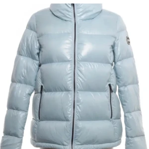 Ljusblå Colmar dunjacka - Säljer en snygg ljusblå dunjacka från Colmar (tjockare dun än den klassiska modellen) med hög krage och blå dragkedjor. Storlek 42 italiensk storlek vilket motsvarar ungefär small. Inköpt för ca 4000-5000 kr på Jackie’s för några år sedan, superfint skick och inga slitningar förutom att en liten söm på colmarloggan gått upp lite (se sista bild)🌼🌼 skriv för fler bilder/frågor!