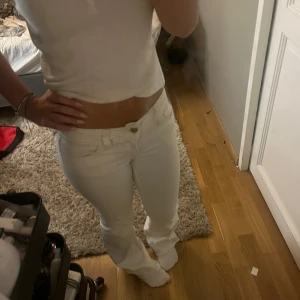 Vita bootcut jeans från Cheap Monday - Säljer ett par vita jeans från Cheap Monday med bootcut-modell och råa kanter nertill. Byxorna har låg midja och klassisk femficksdesign. Snygg logga bak på linningen och stretchigt bomullsmaterial som sitter skönt.