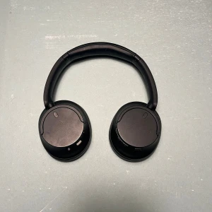 Sony WH-CH720N - Sony WH-CH720N är trådlösa over-ear-hörlurar med aktiv brusreducering och Bluetooth 5.2. De har en bekväm design med mjuka öronkuddar för långvarig användning. Batteritiden är upp till 35 timmar med brusreducering på, och de laddas snabbt via USB-C. De levererar klart och balanserat ljud med bra bas.