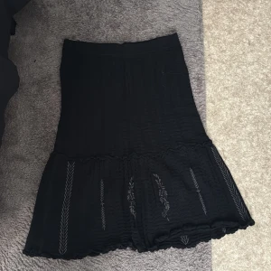 Svart stickad kjol från Odd Molly - ( ONESIZED ) Svart stickad kjol från Odd Molly med broderade detaljer i form av grå blad och kvistar. ( endast använd EN gång ) 