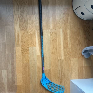 Oxdog innebandyklubba blå 77cm - Oxdog innebandyklubba med blått blad och svart skaft. Greppet ser fräscht ut och bladet är i gott skick utan synliga sprickor. Perfekt för både träning och match. Lätt och smidig klubba för dig som vill ta ditt spel till nästa nivå.