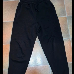 Svarta mjukisbyxor från Only Play XS - Svarta mjukisbyxor från Only Play i storlek XS. Byxorna har resår och snörning i midjan för skön passform. Tillverkade i mjukt material, perfekta för chill eller träning. Klassisk rak modell med enkel design.