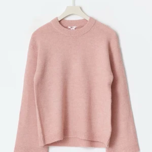 Ljusrosa stickad tröja - Mysig ljusrosa stickad tröja med rund hals och långa ärmar. Tröjan har en avslappnad passform och ribbade muddar vid ärmslut och nederkant. Perfekt för lager-på-lager under kyliga dagar. Jag tycker den är lite stickig i början men efter ett tag blir det bättre. Storlek 170