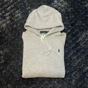 Ralph Lauren Hoodie - Säljer min gråa Ralph Lauren hoodie då den inte kommer till nån användning längre. Hoodien är i fint skick. Såklart äkta också, de finns QR-kod vid storlekslappen som kan bevisa att den är äkta. Nypriset ligger på 2200kr, mitt pris 900kr. Om du har frågor eller skulle vara intresserad så är det bara att höra av dig🤝