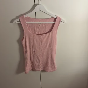 Ljusrosa linnetopp från 157 - Säljer en ljusrosa linnetopp från 157 i mjuk bomull. Toppen är ärmlös med breda axelband och har en klassisk, rundad urringning. Visar inte för mycket och är bekväm. Både med och utan kofta över. 