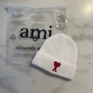 Amii Paris Mössa - Stilren mössa med broderad hjärtlogga framtill. Klassisk ribbstickad modell som passar både till vardag och mer uppklädda outfits. Bekväm passform och tidlös design. Sparsamt använd och i mycket fint skick. 